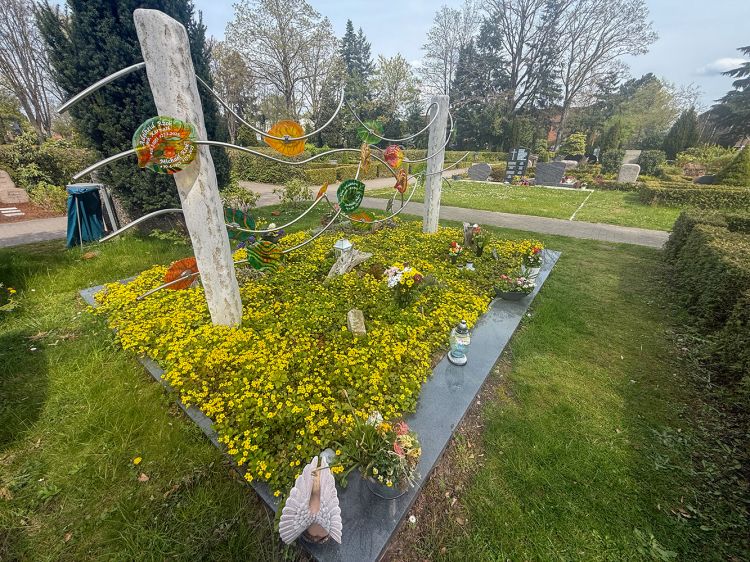 Grabanlage mit bunten Glasblättern und gelben Boden-Decker und Wurzeln. Grabanlage mit bunten Glasblättern und gelben Boden-Decker und Wurzeln.