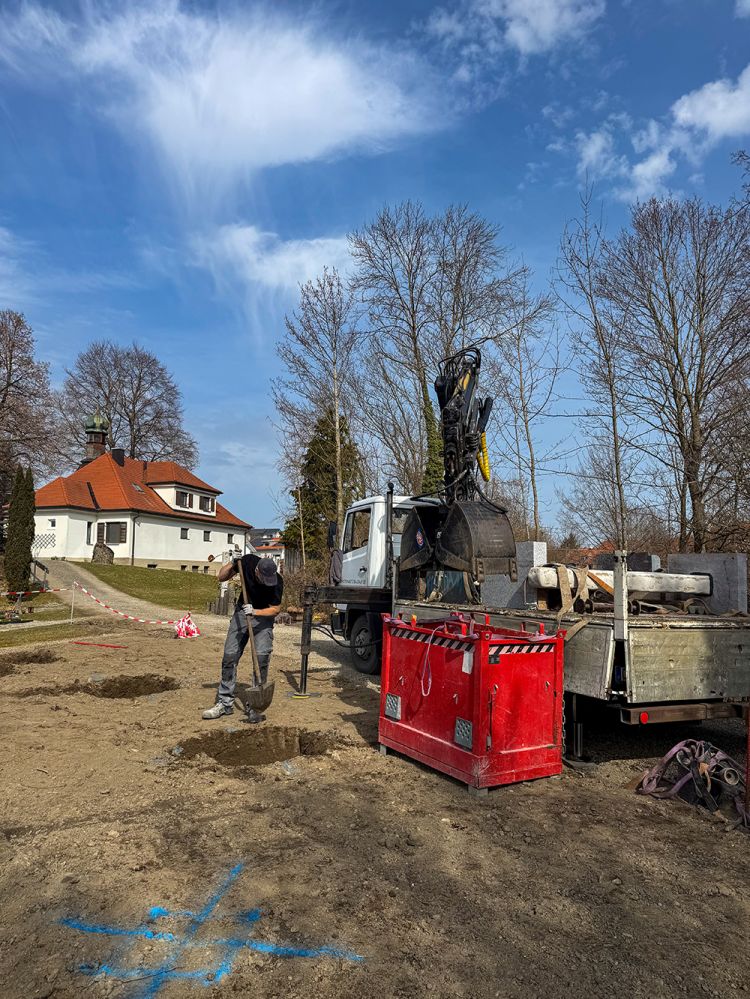 Ein Mann ist auf einem Friedhof mit dem Bau einer Gemeinschafts-Grabanlage beschäftigt. Ein Mann ist auf einem Friedhof mit dem Bau einer Gemeinschafts-Grabanlage beschäftigt.