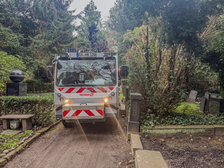 LKW fährt auf engen Wegen auf dem alten Friedhof LKW fährt auf engen Wegen auf dem alten Friedhof