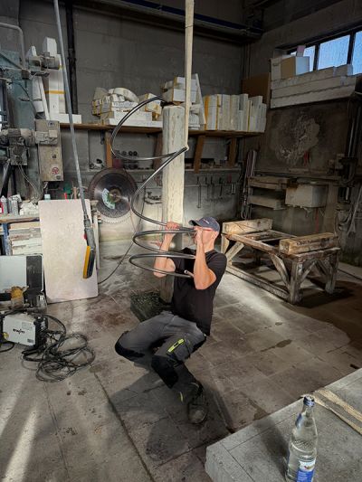 Person biegt ein Edelstahlrohr von Hand mit vollem Körpereinsatz